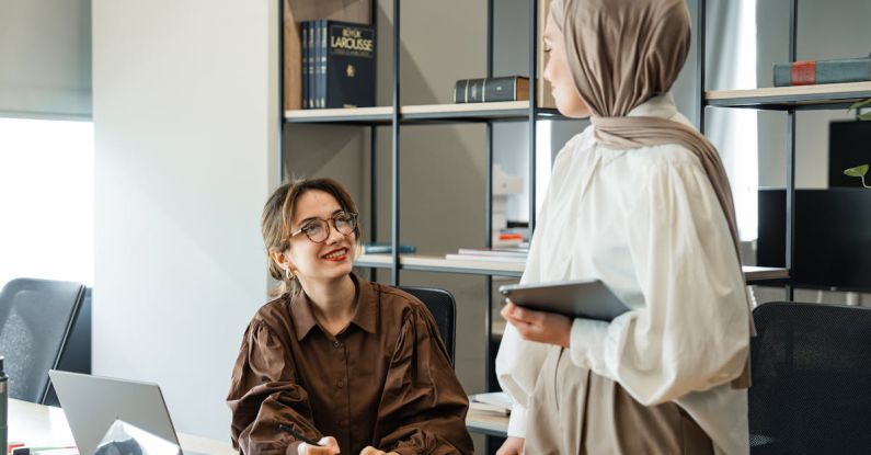 Mentorship Meeting - Two women in hijab talking in an office