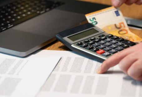 Cash Calculator - Man Hands over Documents and Calculator