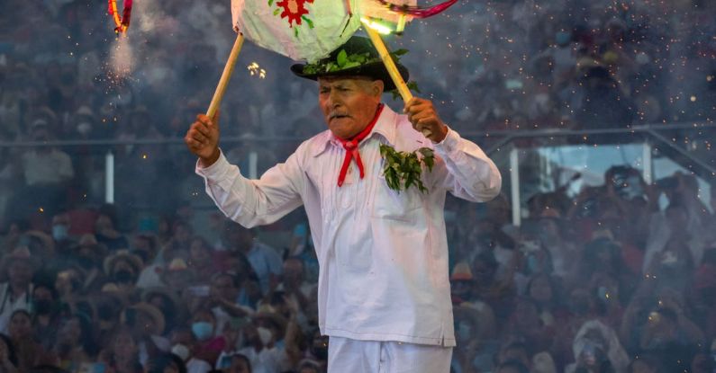 Early Stage - A man in white holding a firework on his head