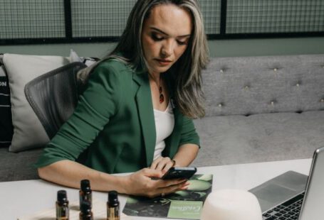 Technology Upgrade - A woman sitting at a desk with a laptop and a bottle of essential oils