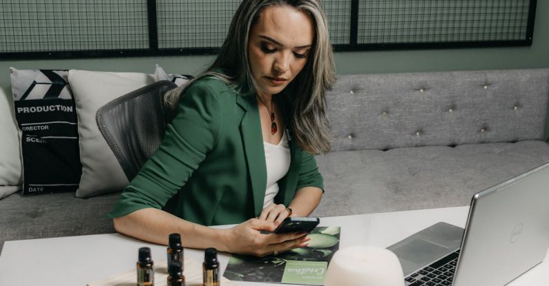 Technology Upgrade - A woman sitting at a desk with a laptop and a bottle of essential oils