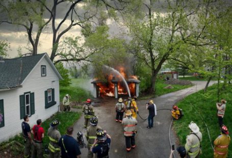 Team Evaluation - Firefighters and people stand around a house with a fire