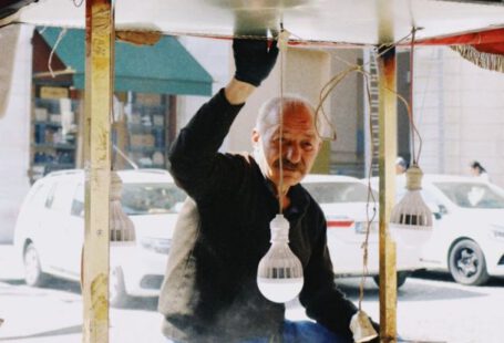 Secondary Market - Elderly Seller of Street Food Standing by Stall